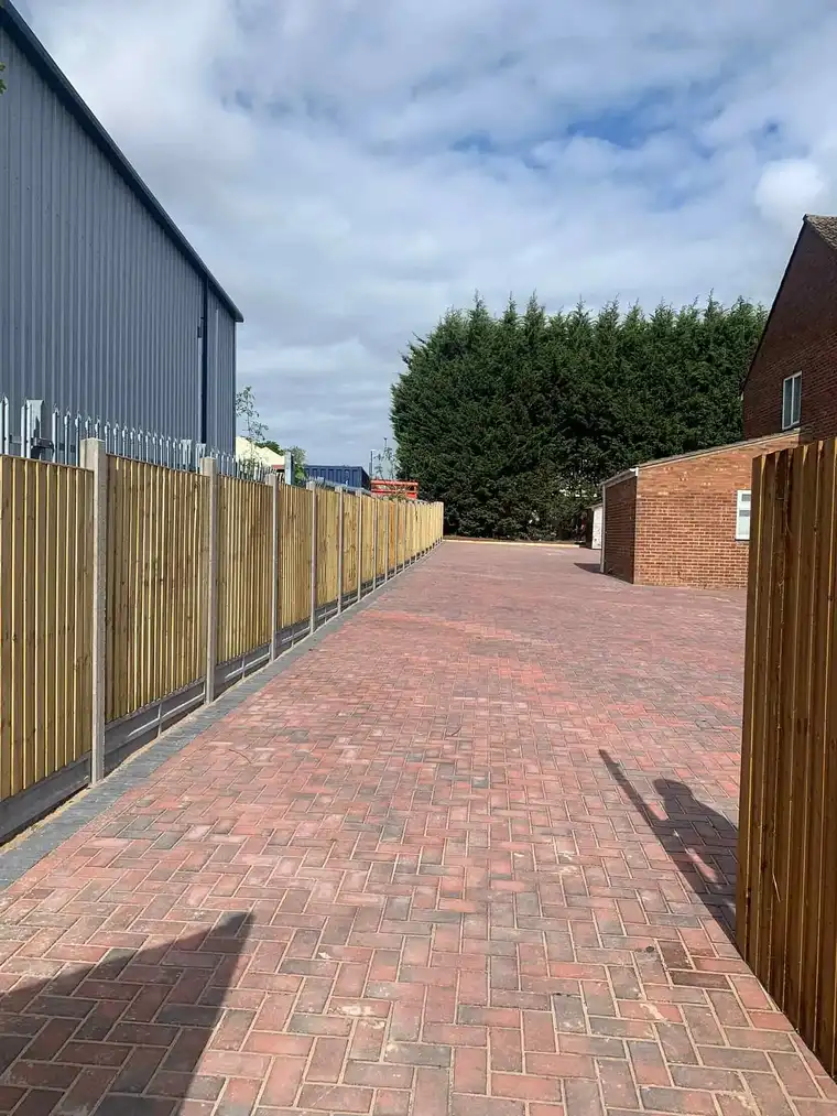 Red brick block paved path with new fencing