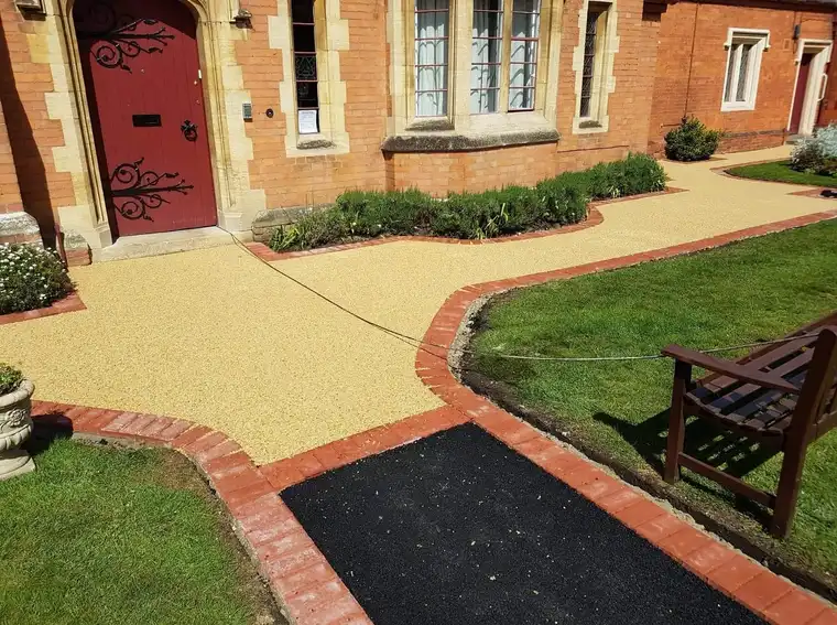 Gold resin path with red brick border across lawned gardens