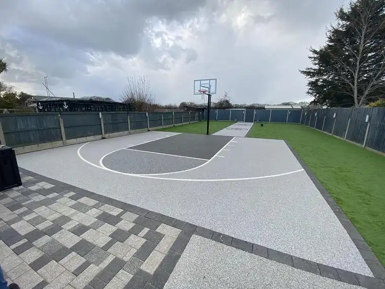 Resin surfaced games court with basketball hoop